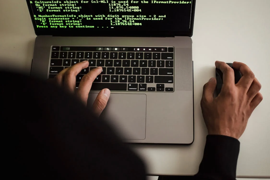 Person using a laptop with code displayed on the screen