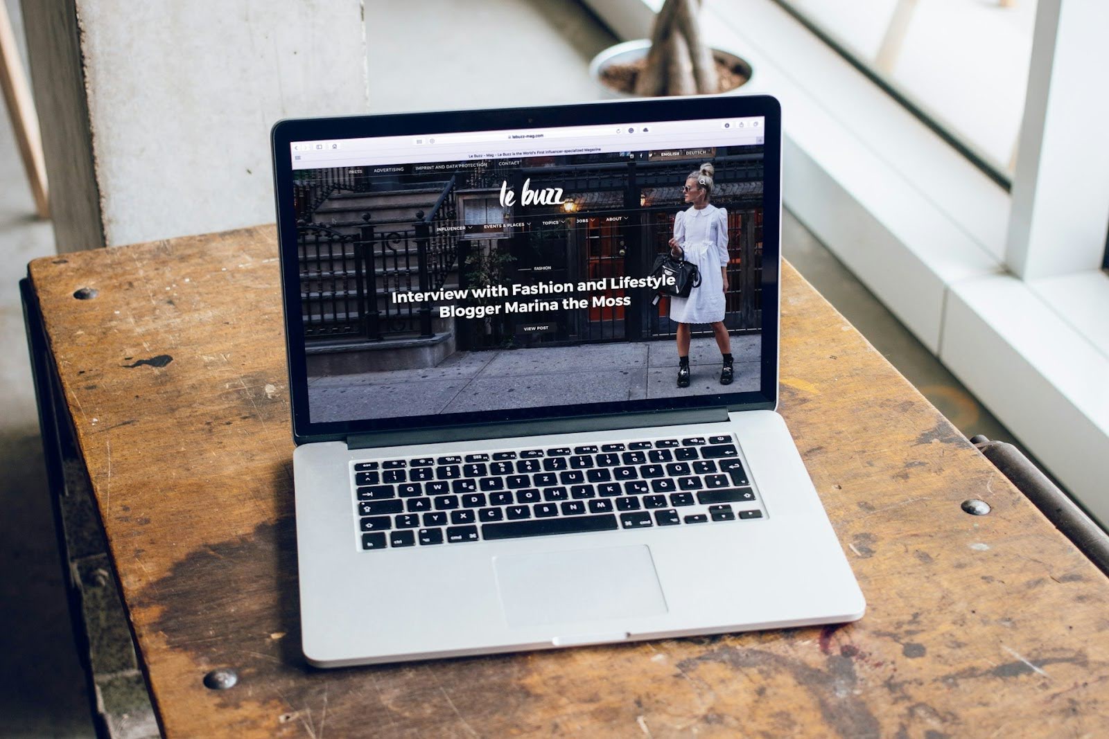 A MacBook Pro with a fashion website shown on the screen